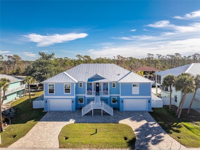 view of front of house with covered porch, a front yard, and a garage