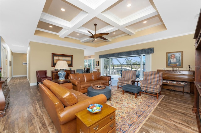 living room with coffered ceiling, hardwood / wood-style flooring, ceiling fan, ornamental molding, and beamed ceiling