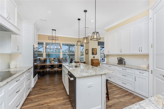 kitchen featuring white cabinetry and an island with sink