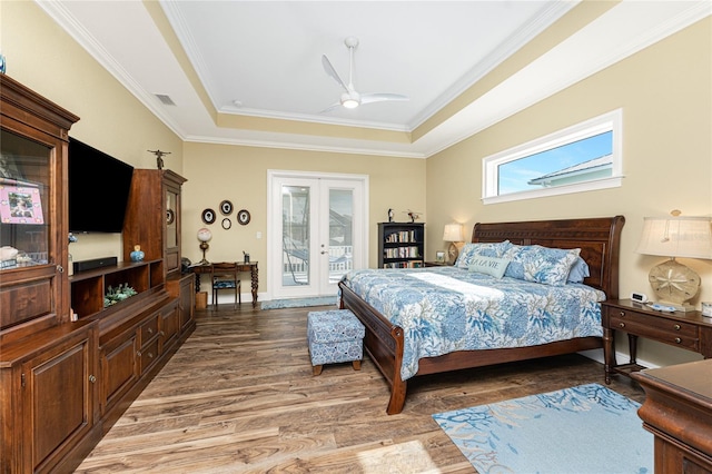 bedroom with french doors, hardwood / wood-style flooring, ceiling fan, access to exterior, and a tray ceiling