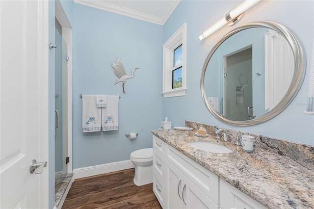 bathroom with hardwood / wood-style floors, vanity, crown molding, toilet, and a shower with shower door