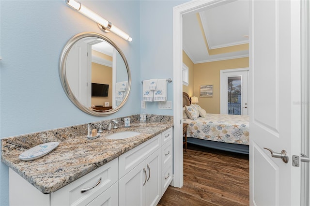 bathroom featuring hardwood / wood-style floors, vanity, and crown molding