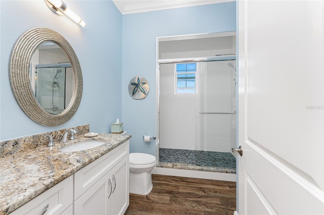 bathroom featuring hardwood / wood-style floors, vanity, crown molding, toilet, and walk in shower