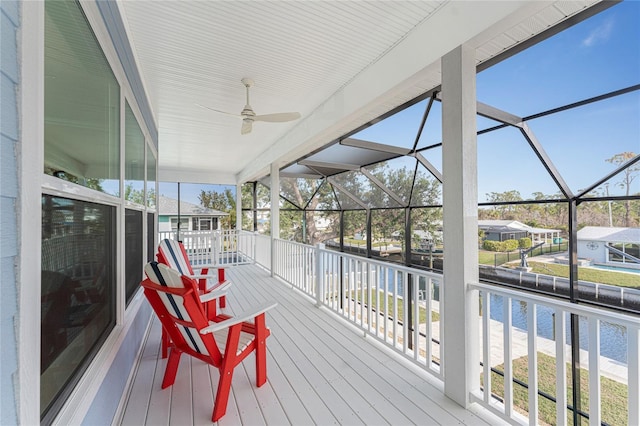 deck with ceiling fan and a water view