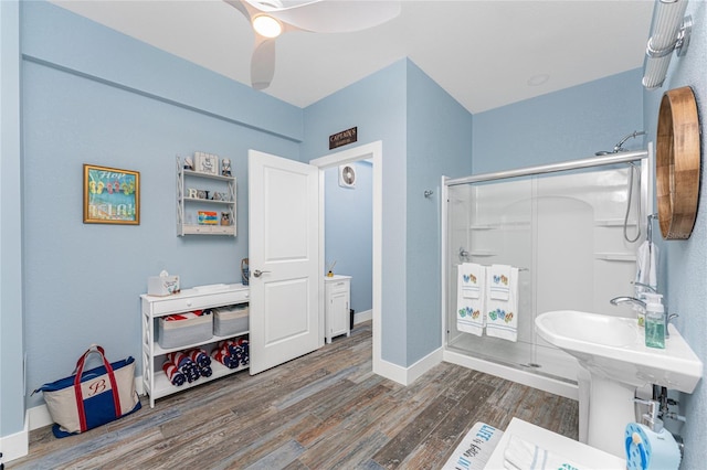 bathroom featuring ceiling fan, wood-type flooring, and walk in shower