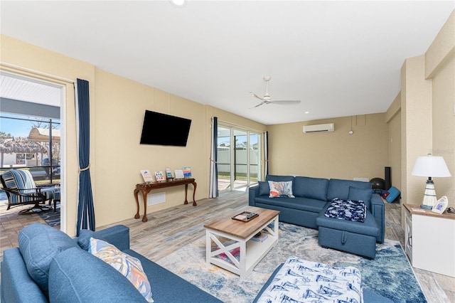 living room with hardwood / wood-style floors, ceiling fan, and an AC wall unit