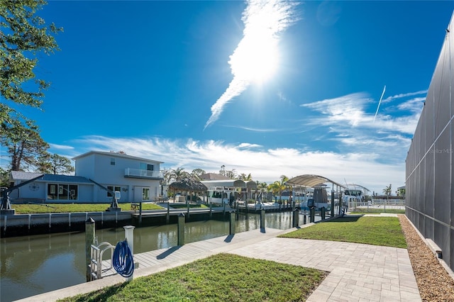 dock area with a lawn, glass enclosure, and a water view