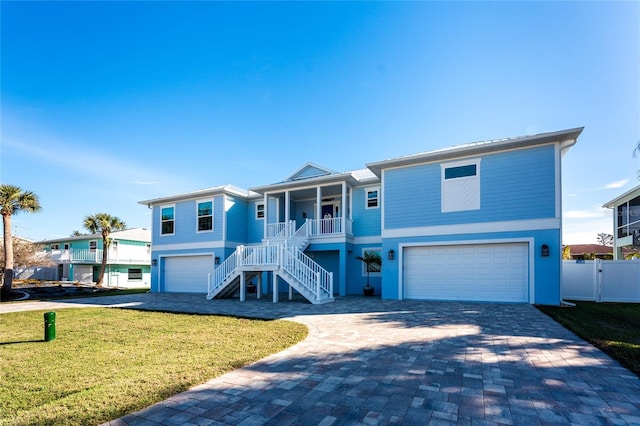 view of front of property featuring a porch, a garage, and a front yard