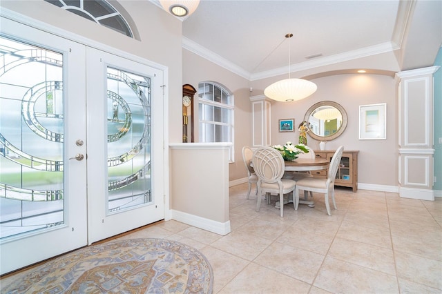 tiled foyer with ornate columns, crown molding, and french doors