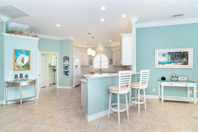 kitchen with crown molding, white fridge with ice dispenser, decorative light fixtures, light tile patterned flooring, and white cabinetry