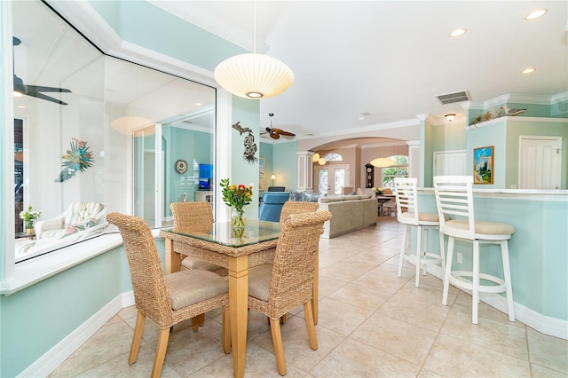 tiled dining room with ornate columns, ceiling fan, and ornamental molding