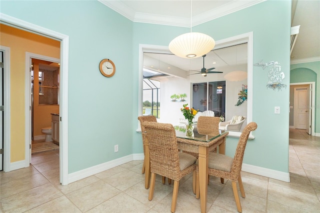 tiled dining space with ceiling fan and ornamental molding