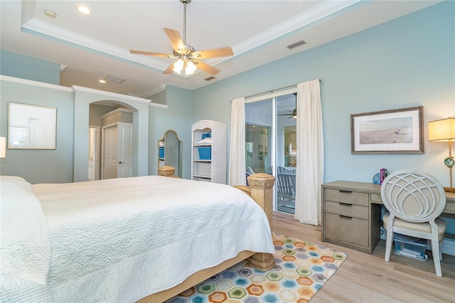 bedroom with access to exterior, ceiling fan, light hardwood / wood-style flooring, a tray ceiling, and ornamental molding