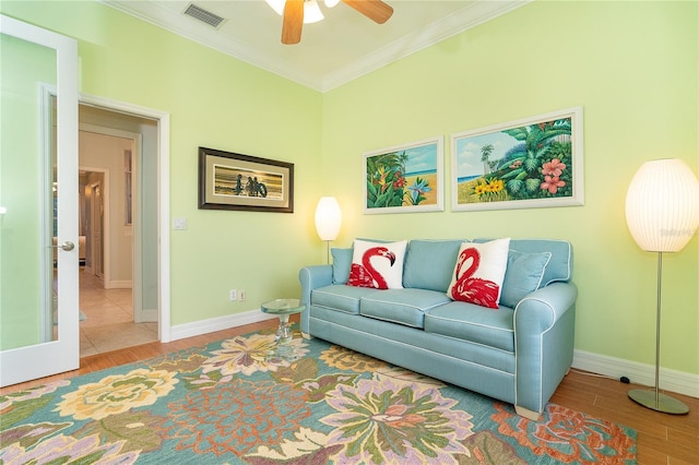 living room featuring hardwood / wood-style floors, ceiling fan, and ornamental molding