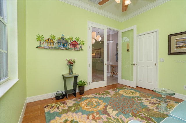 bedroom with french doors, ceiling fan, crown molding, hardwood / wood-style flooring, and a closet