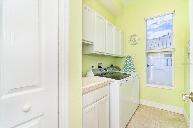 laundry area with cabinets, light tile patterned floors, and separate washer and dryer