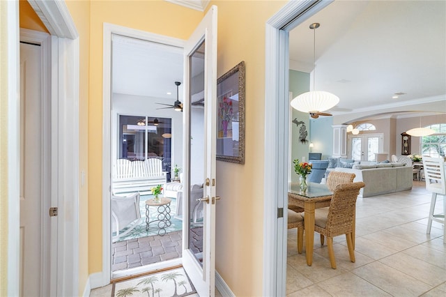 corridor with french doors, light tile patterned floors, and ornamental molding