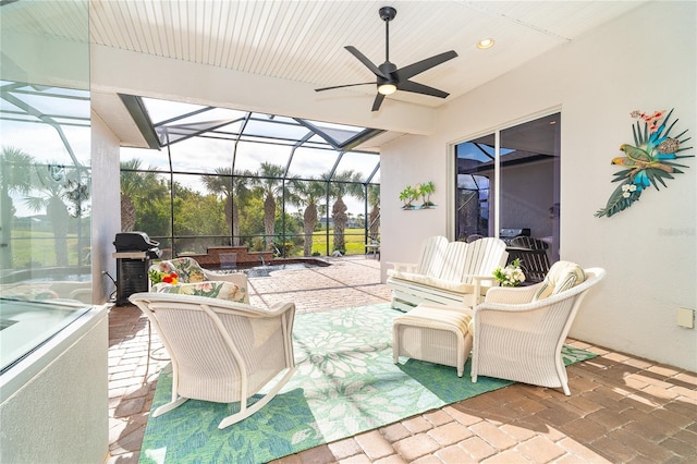 view of patio featuring area for grilling, glass enclosure, and ceiling fan