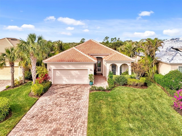 mediterranean / spanish home featuring a front yard and a garage