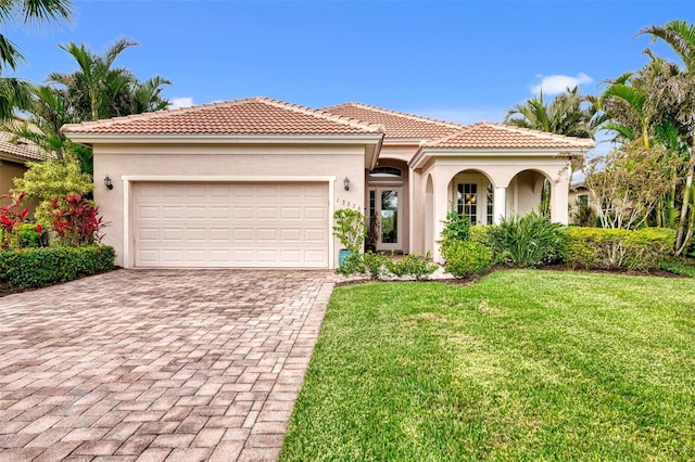 mediterranean / spanish home with a front lawn and a garage