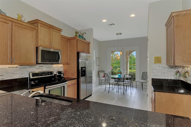 kitchen featuring sink, tasteful backsplash, pendant lighting, and appliances with stainless steel finishes