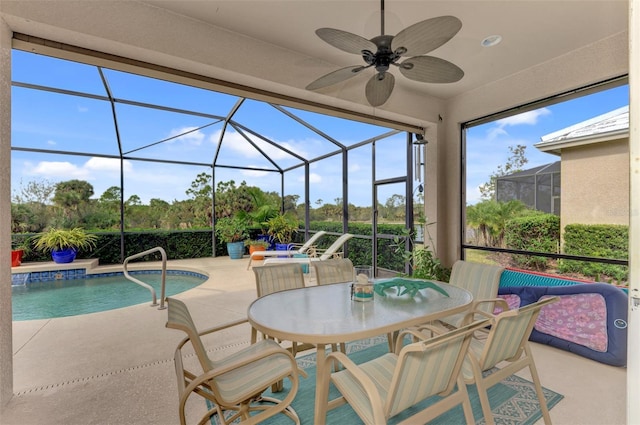 view of swimming pool featuring ceiling fan, a patio, and glass enclosure