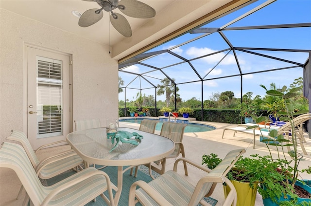 view of patio / terrace featuring a ceiling fan, glass enclosure, outdoor dining space, and an outdoor pool