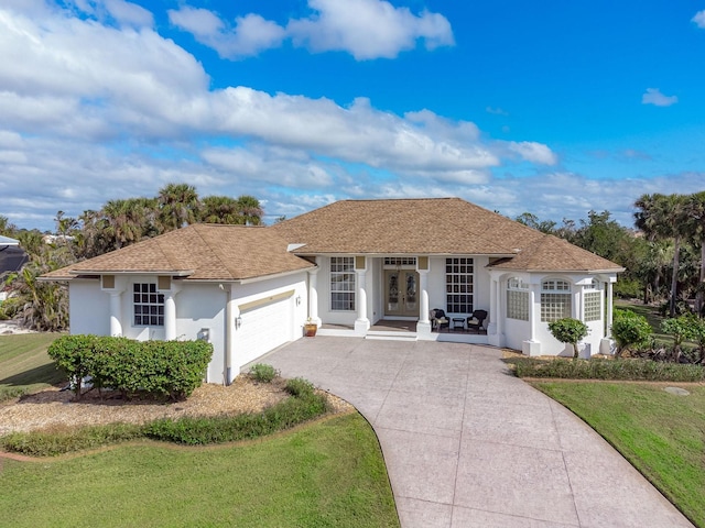 ranch-style house featuring a front yard and a garage