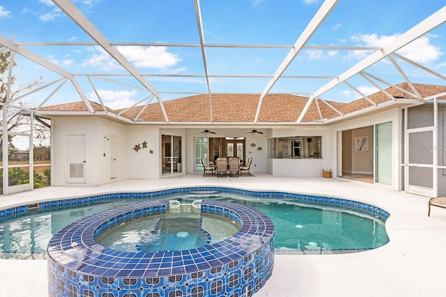 view of swimming pool with glass enclosure, a patio, a pool with connected hot tub, and ceiling fan