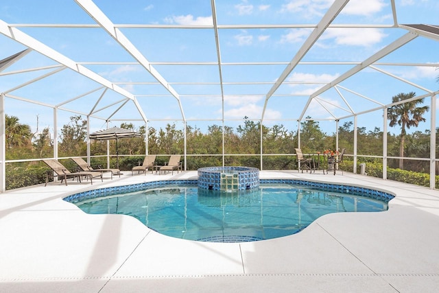 view of swimming pool featuring a patio area, glass enclosure, and a pool with connected hot tub