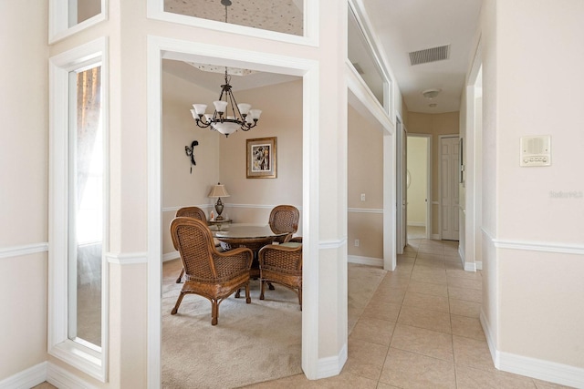 dining room with visible vents, baseboards, a chandelier, light colored carpet, and light tile patterned floors