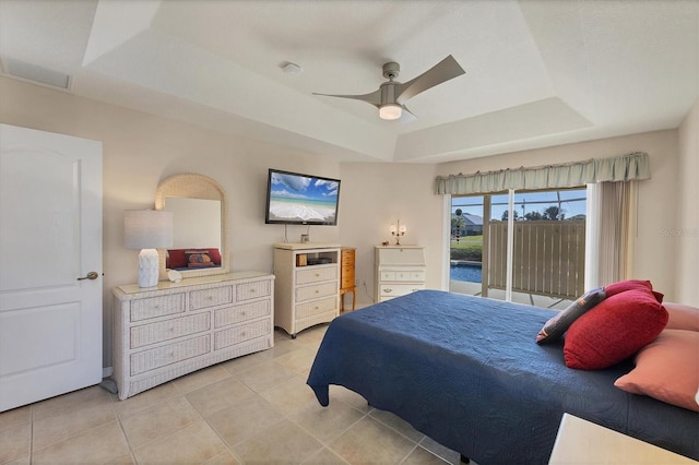 tiled bedroom featuring a tray ceiling, access to exterior, and ceiling fan