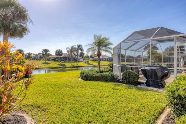 view of yard with a water view and a lanai