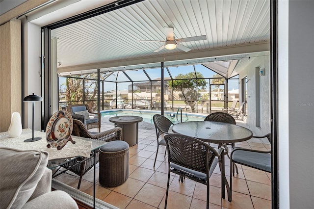 sunroom with ceiling fan and a swimming pool