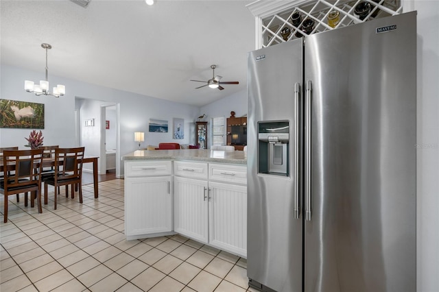 kitchen featuring ceiling fan with notable chandelier, stainless steel fridge, decorative light fixtures, light stone counters, and white cabinetry