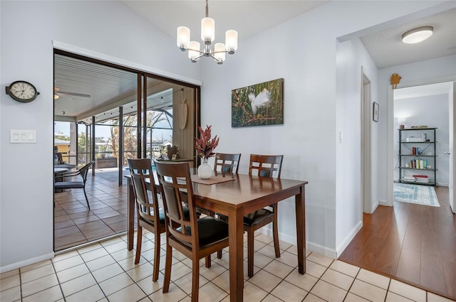 tiled dining area featuring ceiling fan with notable chandelier