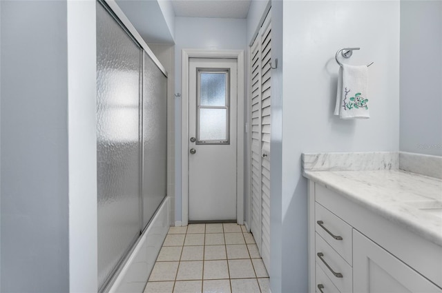 bathroom featuring tile patterned flooring, vanity, and combined bath / shower with glass door