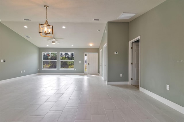 spare room with ceiling fan with notable chandelier