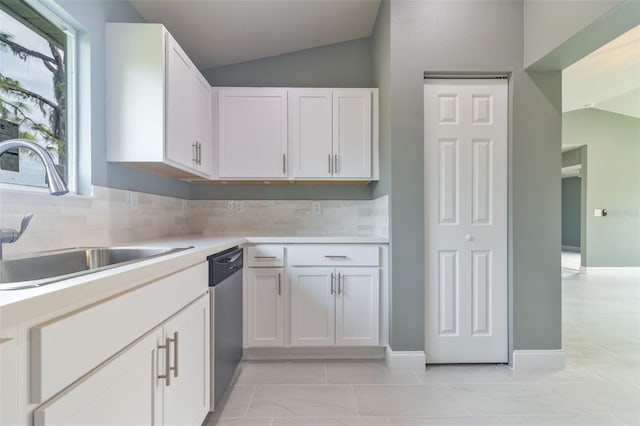 kitchen with white cabinets, vaulted ceiling, and sink