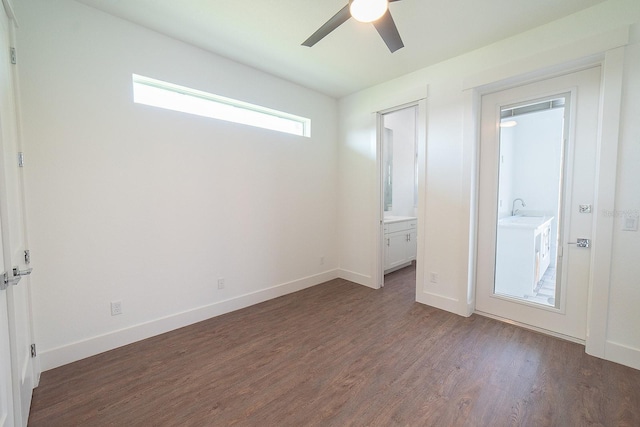 unfurnished bedroom featuring ceiling fan, sink, dark wood-type flooring, and connected bathroom