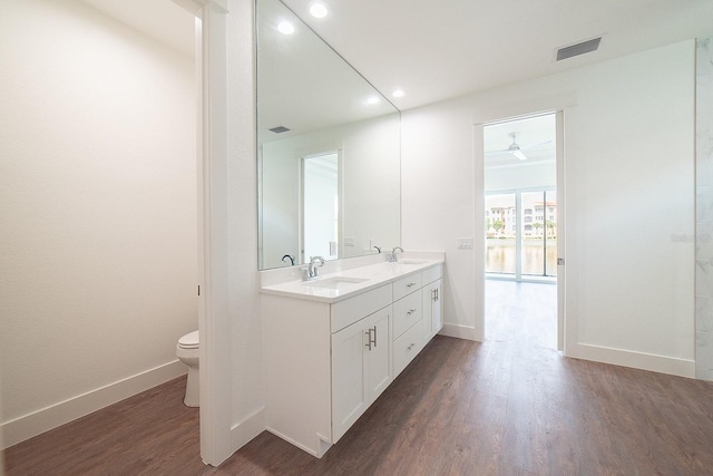 bathroom with wood-type flooring, vanity, and toilet