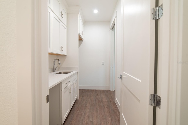 interior space featuring white cabinets, dark hardwood / wood-style floors, and sink