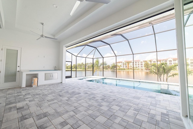 view of pool with ceiling fan and a water view