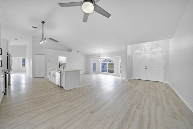 unfurnished living room with ceiling fan with notable chandelier, light wood-type flooring, lofted ceiling, and sink