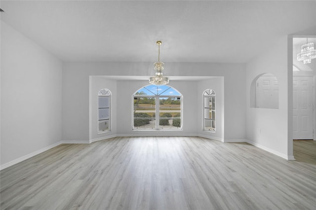 unfurnished room with light hardwood / wood-style floors and a notable chandelier