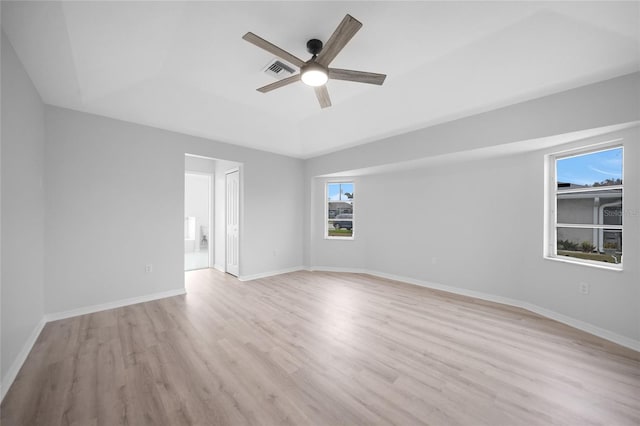 unfurnished room featuring ceiling fan, a raised ceiling, and light wood-type flooring