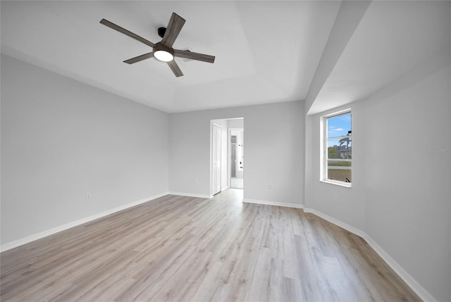 unfurnished room featuring ceiling fan, a raised ceiling, and light wood-type flooring