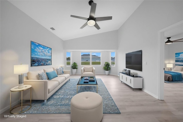 living room featuring ceiling fan, high vaulted ceiling, and light hardwood / wood-style flooring