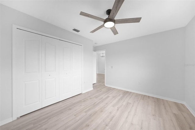 unfurnished bedroom with ceiling fan, light wood-type flooring, and a closet