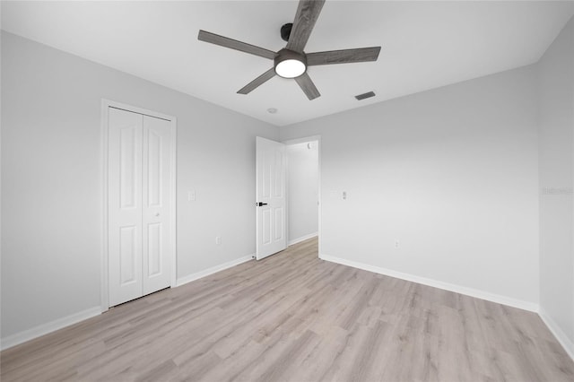 unfurnished bedroom featuring ceiling fan, a closet, and light hardwood / wood-style floors